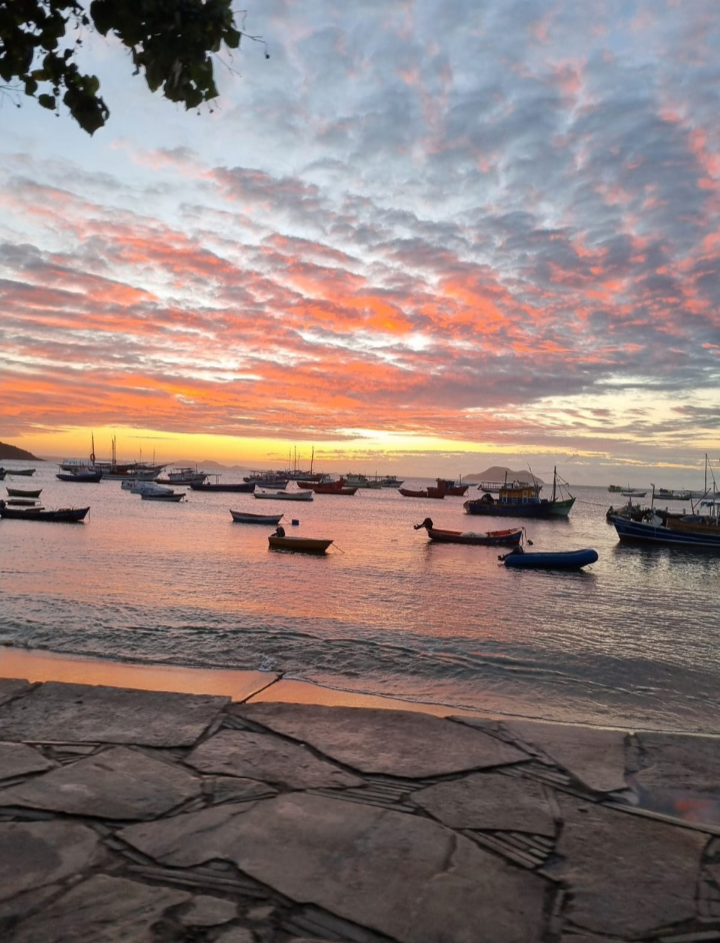 Silhueta de um buggy contra um pôr do sol vibrante em um mirante de Búzios