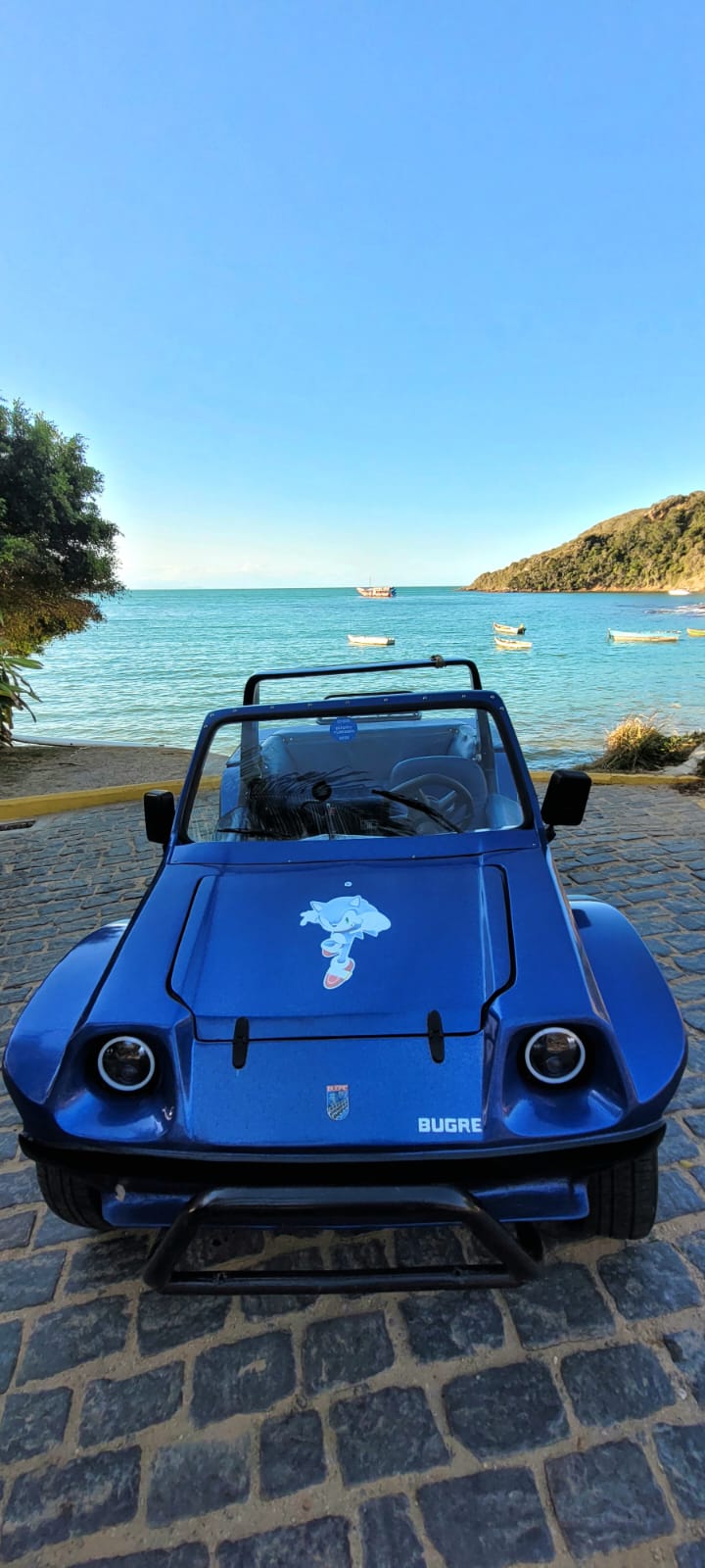 Buggy privativo estacionado em uma praia deserta em Búzios com águas cristalinas ao fundo