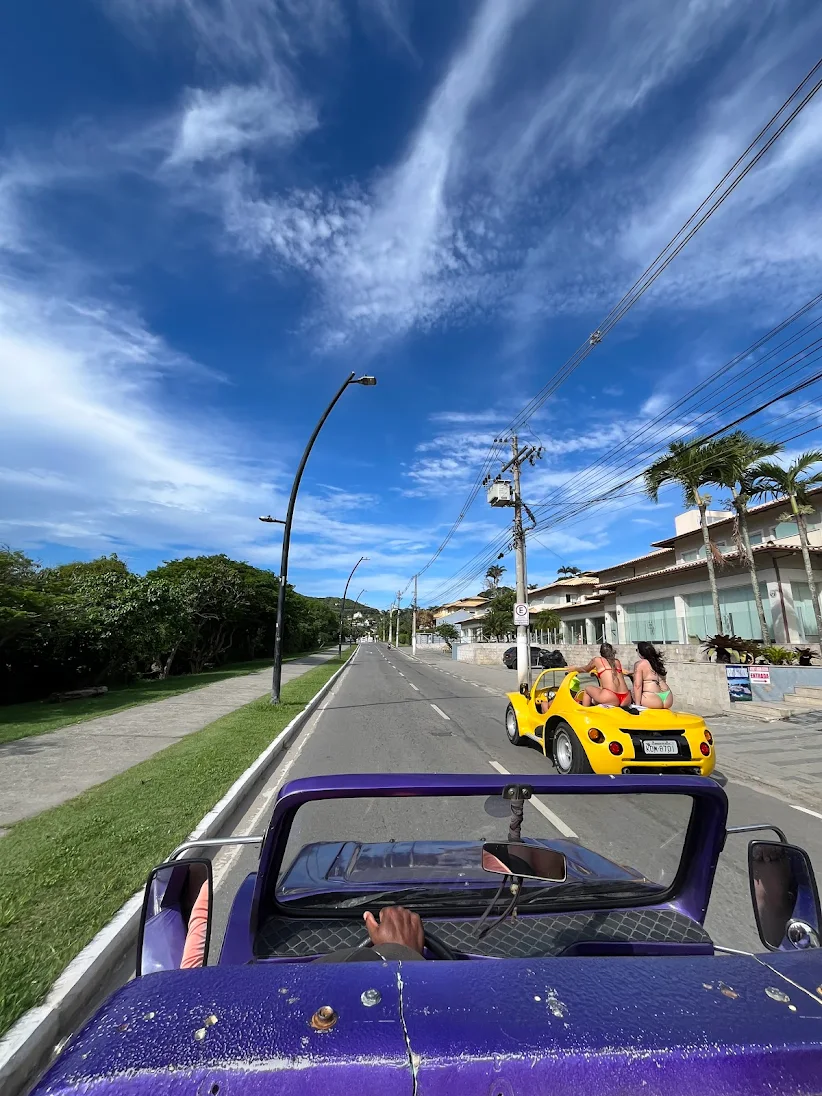 Motorista de buggy certificado sorrindo ao lado de um buggy limpo e revisado em Búzios
