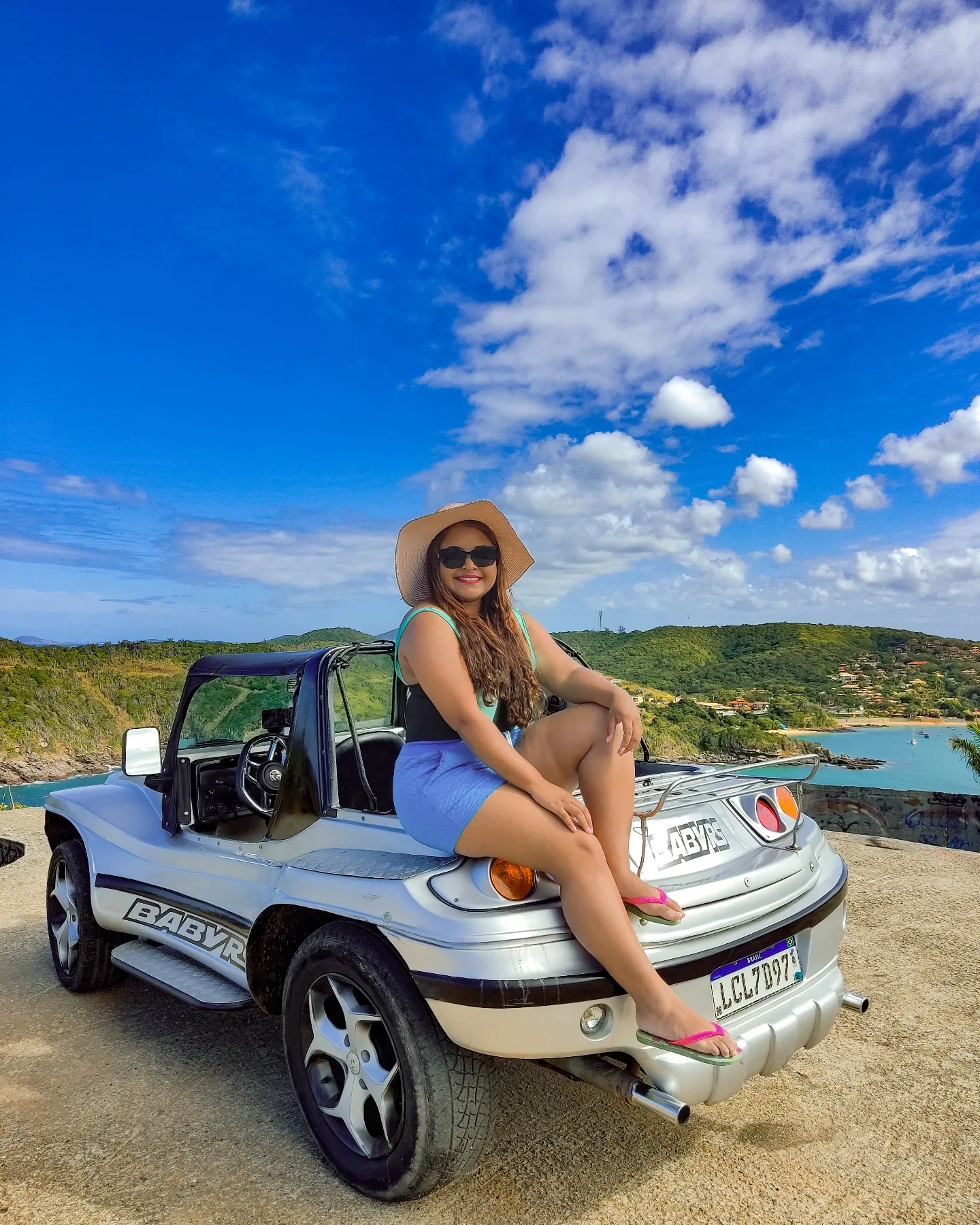 Turistas agasalhados levemente aproveitando um dia ensolarado e de céu azul a bordo de um buggy da Buggy Búzios durante o inverno.