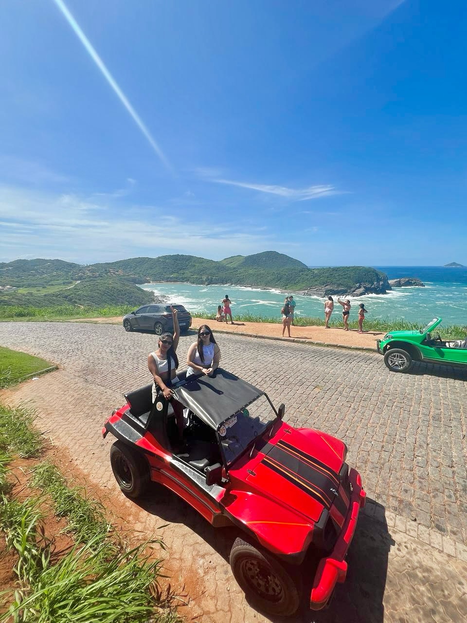 Un buggy de alquiler rosa estacionado frente a la costa de Búzios listo para ser entregado a turistas.