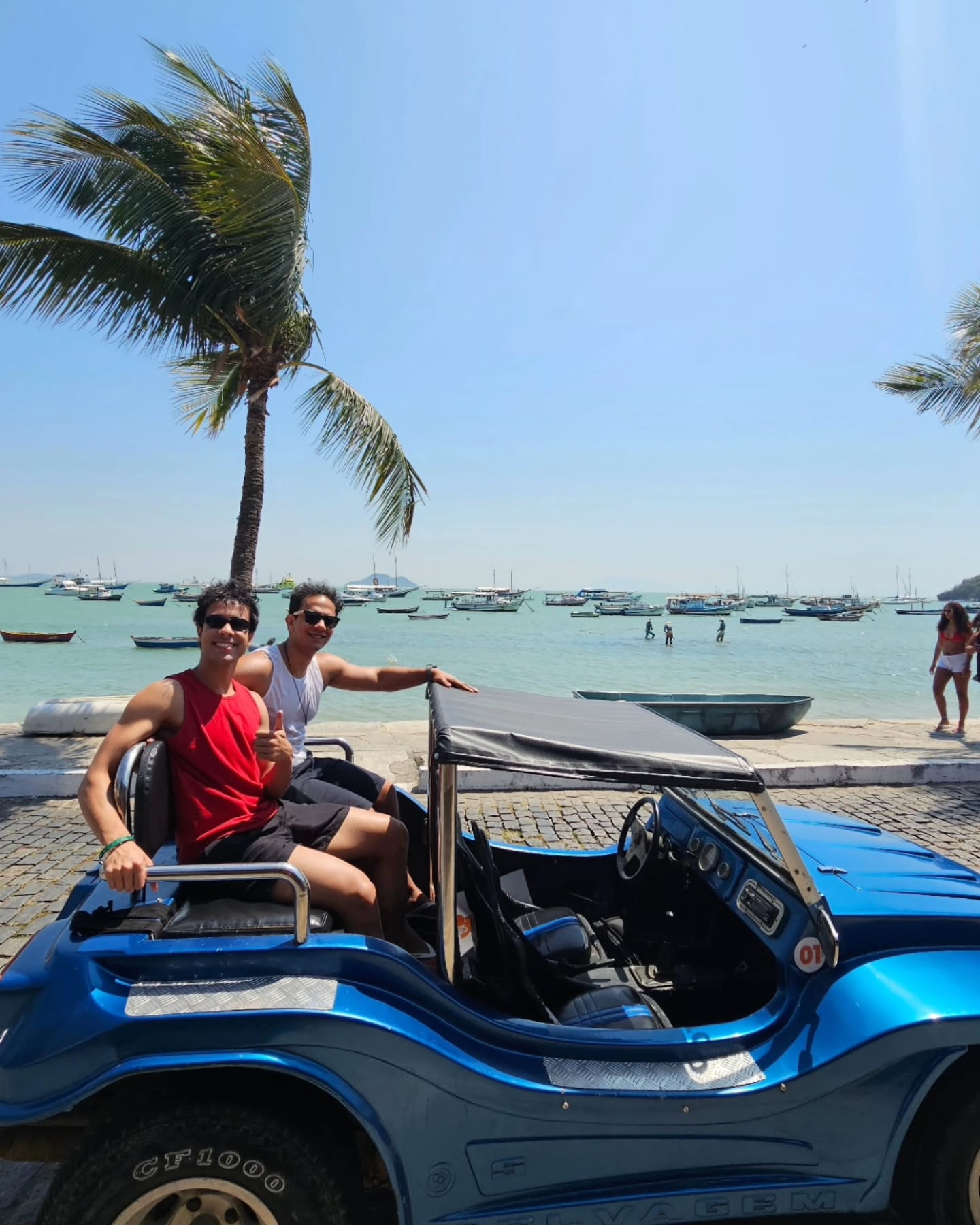 Casal aproveitando o passeio estendido de buggy amarelo com vista panorâmica para a linda Praia de Geribá em Búzios.