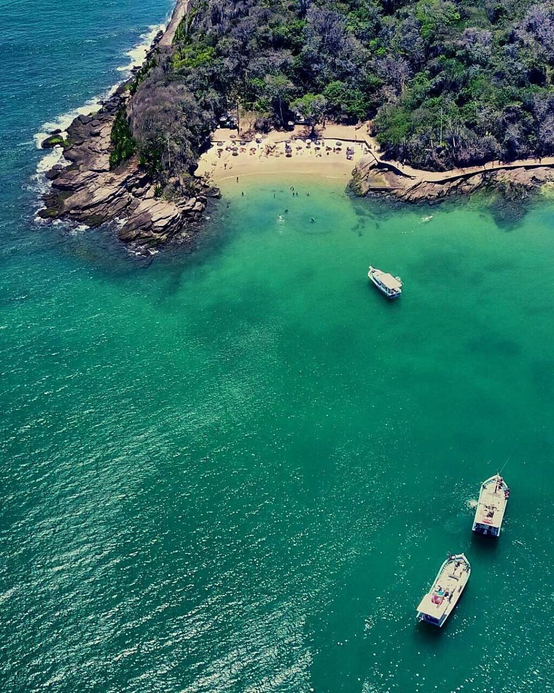Passengers enjoying the top deck of a scenic boat tour in Búzios Brazil with turquoise water