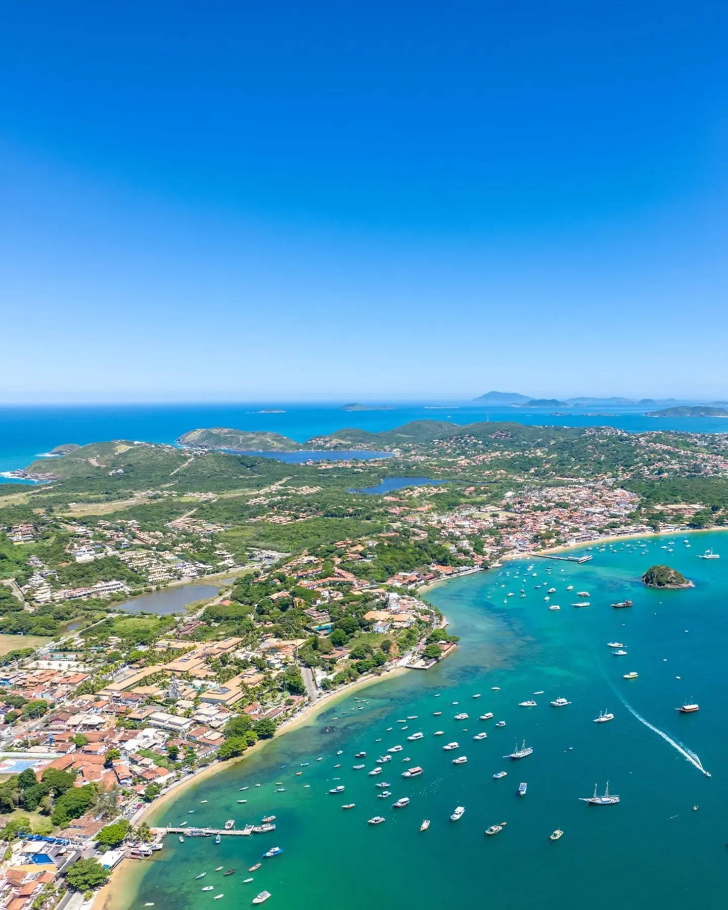 Tourists snorkeling and swimming in the crystal-clear waters of João Fernandes beach during a boat tour in Búzios.