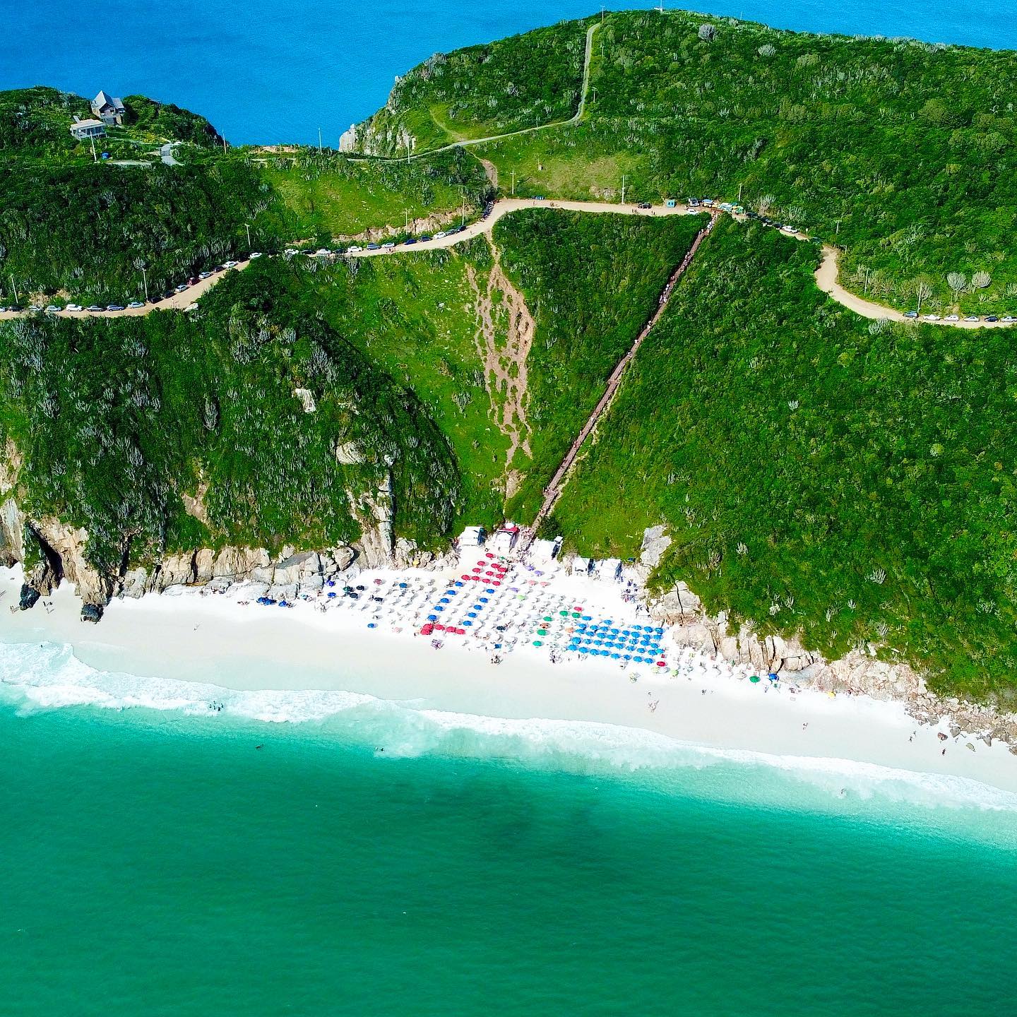 Família com crianças usando coletes salva-vidas a bordo de um barco com tobogã durante o passeio a Arraial do Cabo saindo de Búzios.
